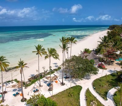 Discover the pristine beauty of a tropical beach resort in Zanzibar with turquoise waters and palm trees.